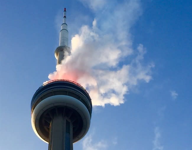 Smoke comes off the CN Tower in Toronto on Thursday July 9, 2015. Social media exploded Thursday night with reports that the CN Tower in Toronto was ablaze. Toronto fire officials say they responded to the reports and determined the smoke was from a fireworks display connected with the Pan Am Games, which officially open on Friday. THE CANADIAN PRESS/Ashton Lawrence