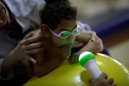 Luana Vieira, who is two years old, and was born with microcephaly, reacts to stimulus during an evaluation session with a physiotherapist at the Altino Ventura rehabilitation center in Recife, Brazil, August 6, 2018. Luana's mother Rosana Vieira Alves has three daughters. "It's hard to manage the girls. Some of them are jealous, but Luana needs more care. In time, they'll understand." Rosana does not have any family support and is overwhelmed by the cost of housing and Luana's medicines. She counts it a victory that she has managed to get a wheelchair for Luana, and worries about the four surgeries her daughter needs to correct problems with her eyes, her gut and the position of her hips and feet. The demands have taken Rosana to some dark places, and she confesses that she has considered suicide. But she still dreams of a better future, and hopes to get a degree in accounting or civil engineering. REUTERS/Ueslei Marcelino