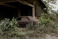 A car parked in a house garage is covered with ashes from the errupting Taal Volcano in Agoncillo, Batangas City