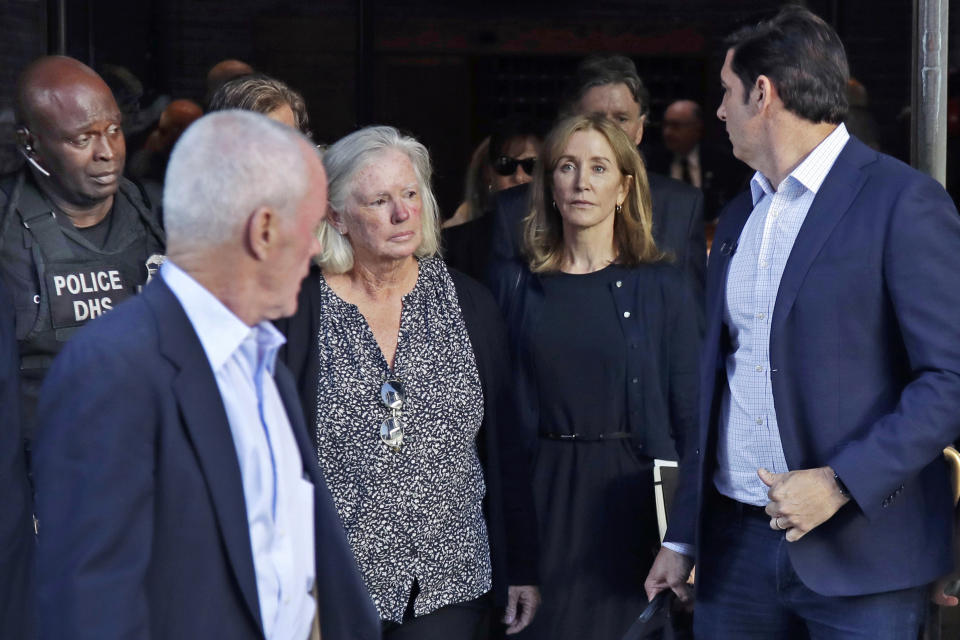 Felicity Huffman, center right, leaves federal court after her sentencing in a nationwide college admissions bribery scandal, Friday, Sept. 13, 2019, in Boston. (AP Photo/Elise Amendola)