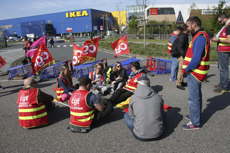 Demonstrators block the access to the Ikea store in protest against the pension reforms in Bayonne, southwestern France, Thursday, April 20, 2023. Union activists stage scattered actions to press France's government to scrap the new law raising the retirement age. (AP Photo/Bob Edme)