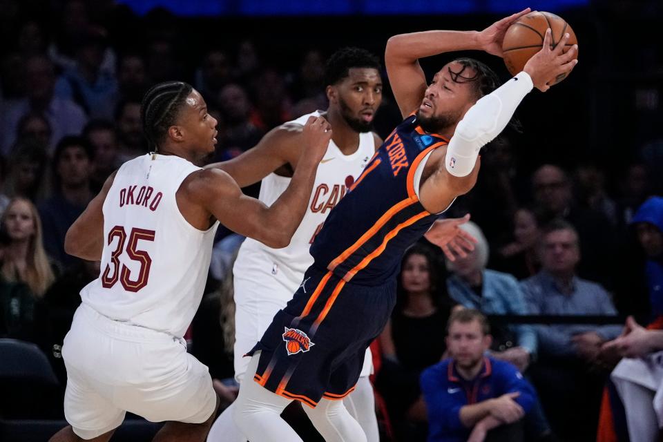New York Knicks' Jalen Brunson, right, protects the ball from Cleveland Cavaliers' Isaac Okoro, left, and Donovan Mitchell during the first half of an NBA basketball game Wednesday, Nov. 1, 2023, in New York. (AP Photo/Frank Franklin II)