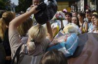 Local residents, many of whom fled the war, gather to hand out donated items such as medicines, clothes, and personal belongings to their relatives on the territories occupied by Russia, in Zaporizhzhia, Ukraine, Sunday, Aug. 14, 2022. Volunteers transport these items across the frontline and distribute them to addresses at their own risk. (AP Photo/Andriy Andriyenko)