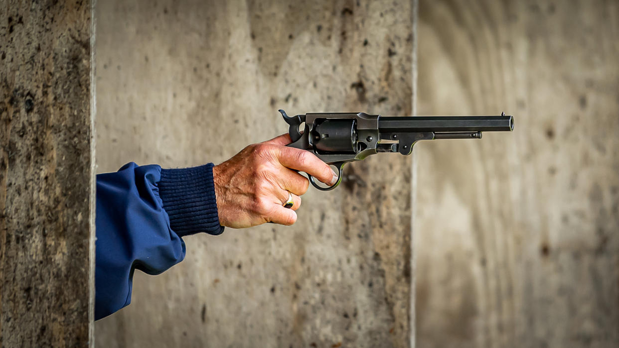  A vintage revolver being aimed at a firing range. 