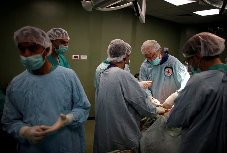 FILE PHOTO: British vascular surgeon John Wolfe, who was invited to Gaza by ICRC, performs a surgery for a wounded Palestinian in the operating room in a hospital in Gaza City