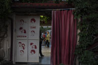 In this Thursday June 4 , 2020 photo moviegoers stand outside the entrance of the Thision outdoor summer cinema where moviegoers watch films under the ancient Acropolis. Cine Thision is one of the oldest open-air movie theaters in Athens, built in 1935. (AP Photo/Petros Giannakouris)