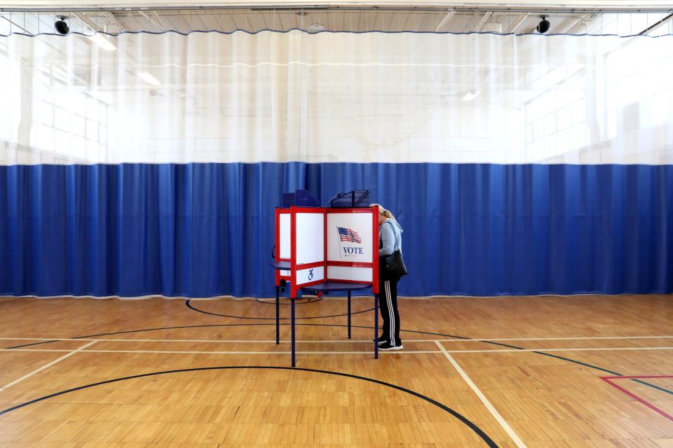 A voter casts her ballot for the school district budget vote and board election at Ridgeway Elementary School May 21, 2024.