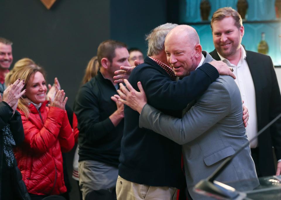 New U of L head football coach Jeff Brohm, right, embraced his former Trinity High School football coach Dennis Lampley following the announcement at Cardinal Stadium in Louisville, Ky. on Dec. 8, 2022.  