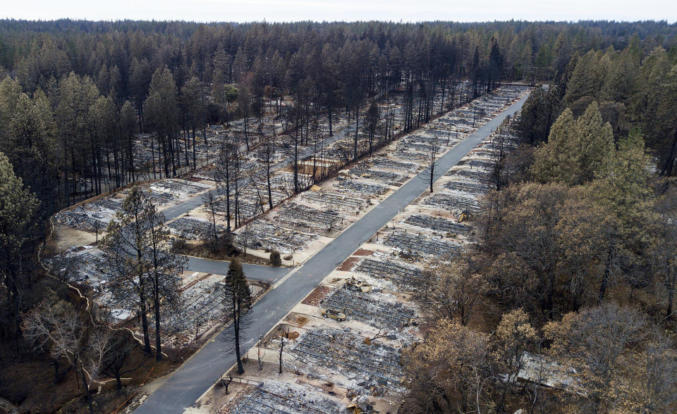 FILE - In this Dec. 3, 2018, file photo, homes leveled by the Camp Fire line the Ridgewood Mobile Home Park retirement community in Paradise, Calif. California’s Pacific Gas & Electric is faced regularly with a no-win choice between risking the start of a deadly wildfire or immiserating millions of paying customers by shutting off the power. (AP Photo/Noah Berger, File)