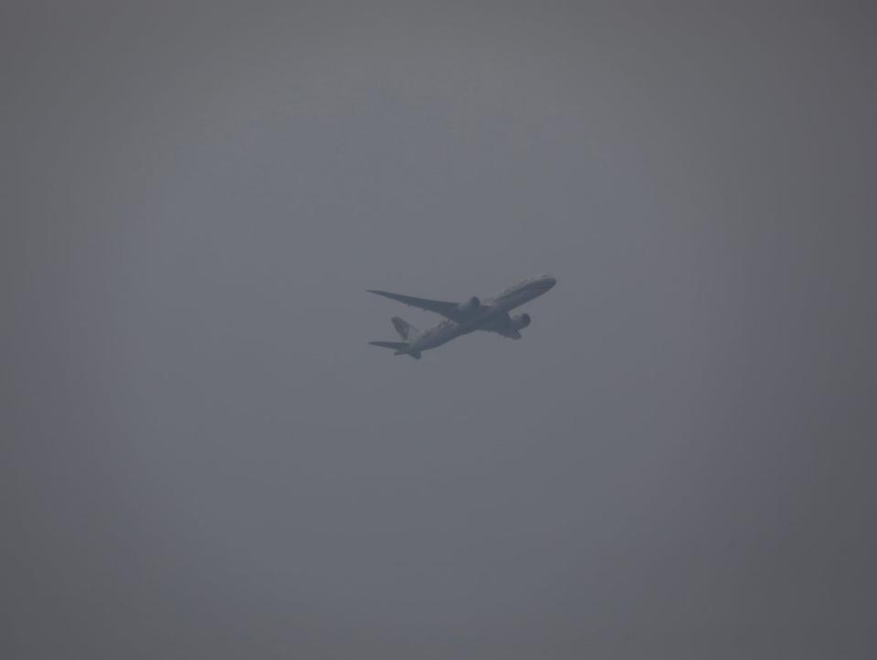 An airplane flies  on a sky shrouded with smog in Taguig city, Philippines (EPA)