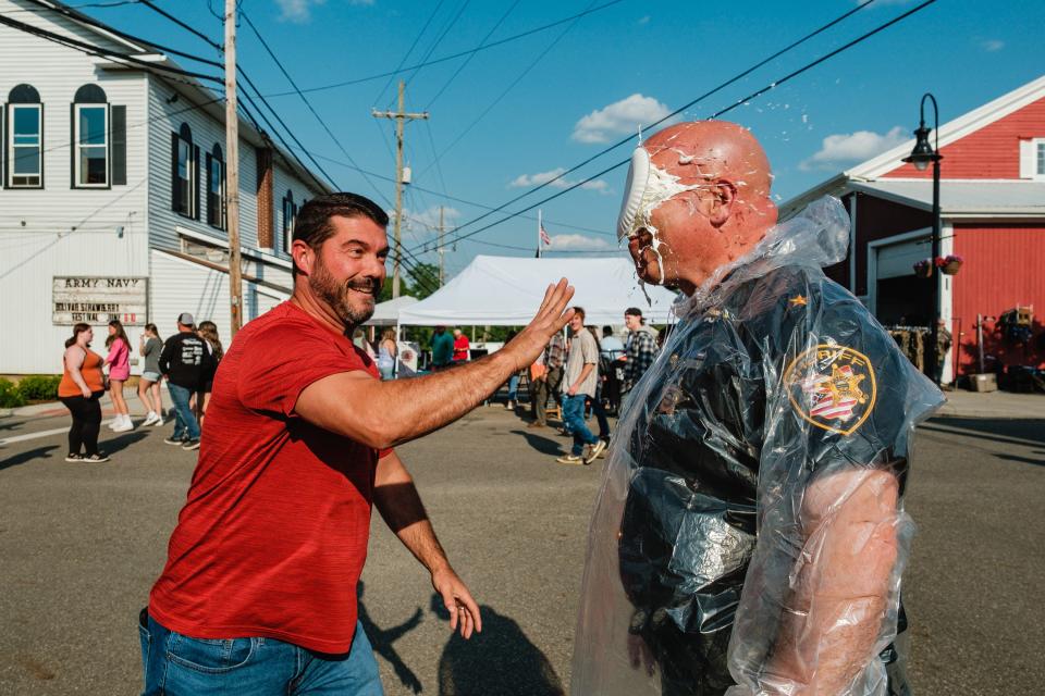 Tuscarawas County Sheriff Orvis Campbell is pied by Isaac Wilson of East Canton during the Bolivar Strawberry Festival Friday, June 9, in Bolivar. Proceeds from an opportunity to pie the sheriff went  towards the Trojan Foundation, whose mission is to "enhance educational opportunities for Tusky Valley students during their time in the school system and to promote post-secondary opportunities through scholarships for college, vocational, and technical schools," according to their website at www.trojanfoundation.org.