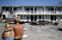 <p> Residents line up for food from the Red Cross outside a damaged motel, Tuesday, Oct. 16, 2018, in Panama City, Fla., where many residents continue to live in the aftermath of Hurricane Michael. Some residents rode out the storm and have no place to go even though many of the rooms at the motel are uninhabitable. (AP Photo/David Goldman) </p>