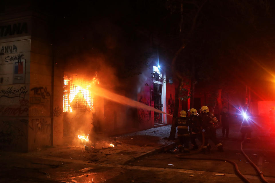 Firemen work to put out flames from a building during an anti-government protest in Santiago, Chile on Oct. 28, 2019. (Photo: Pablo Sanhueza/Reuters)