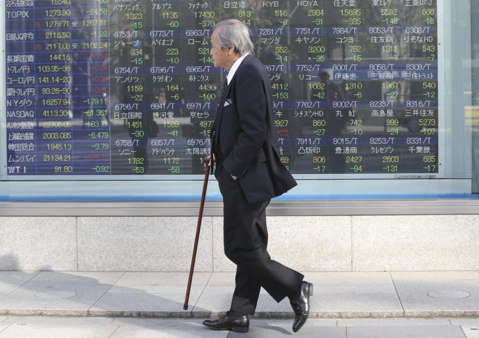 A man walks by an electronic stock board of a securities firm in Tokyo, Tuesday, Jan. 14, 2014. Most Asian stock markets sank Tuesday, led by Japan, following a big sell-off in the U.S.(AP Photo/Koji Sasahara)