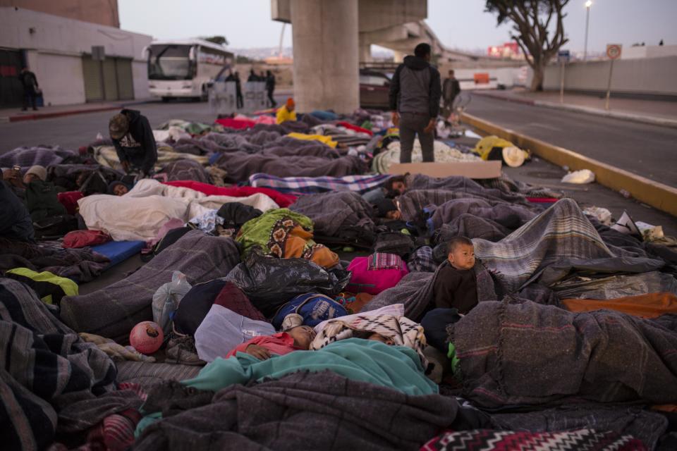 Migrants sleep under a bridge at the Chaparral border crossing in Tijuana, Mexico, Friday, Nov. 23, 2018. The mayor of Tijuana has declared a humanitarian crisis in his border city and says that he has asked the United Nations for aid to deal with the approximately 5,000 Central American migrants who have arrived in the city. (AP Photo/Rodrigo Abd)