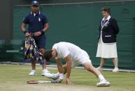 Bulgaria's Grigor Dimitrov slips on the grass against Slovenia's Grega Zemlja during day four of the Wimbledon Championships at The All England Lawn Tennis and Croquet Club, Wimbledon.
