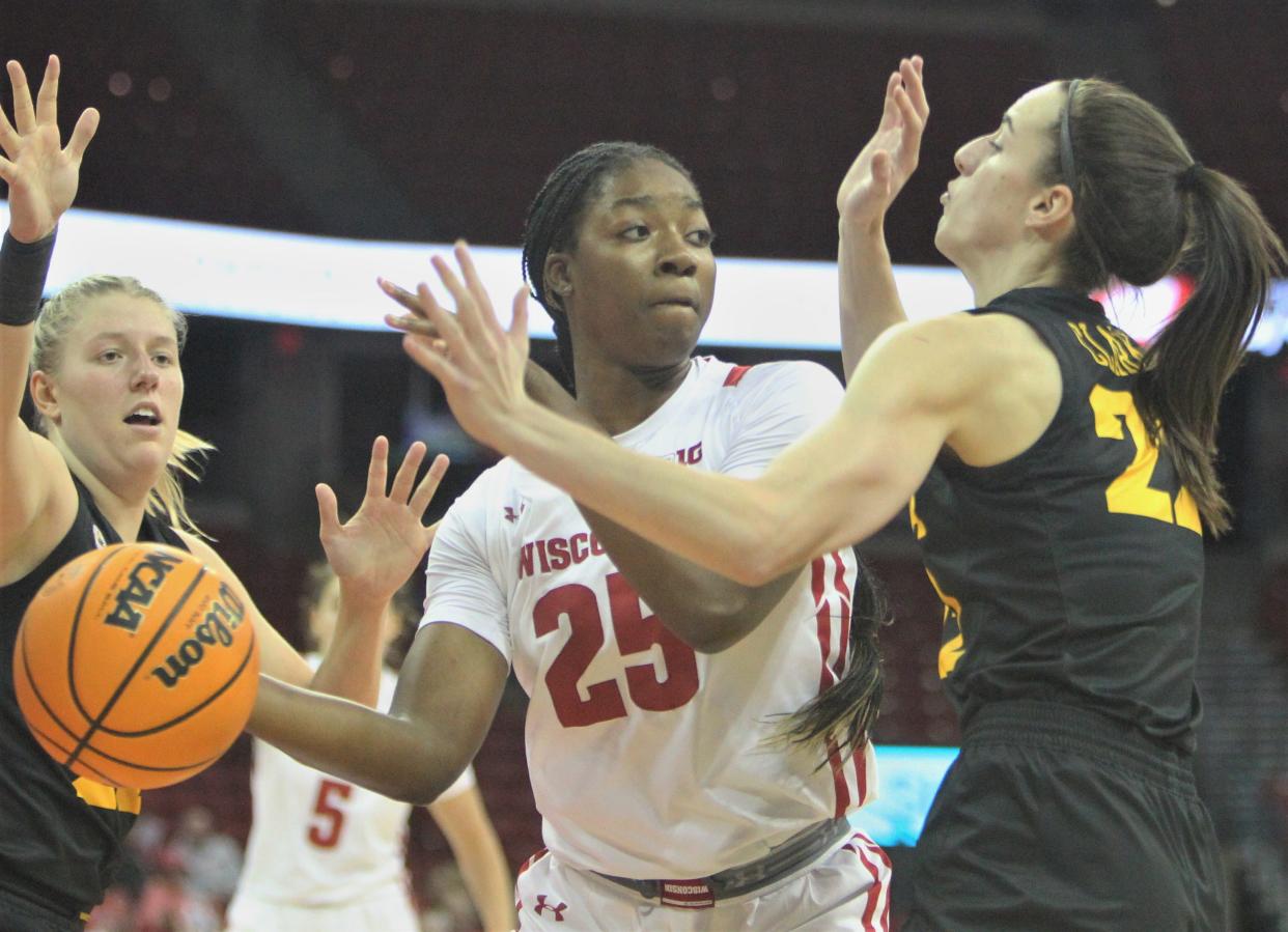 Wisconsin's Serah Williams is double teamed by Iowa's Caitlin Clark (22) and Monika Czinano at the Kohl Center in Madison on Sunday.