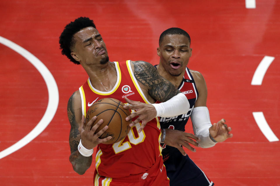 Atlanta Hawks forward John Collins (20) is fouled by Washington Wizards guard Russell Westbrook (4) during the first half of an NBA basketball game Wednesday, May 12, 2021, in Atlanta. (AP Photo/Butch Dill)