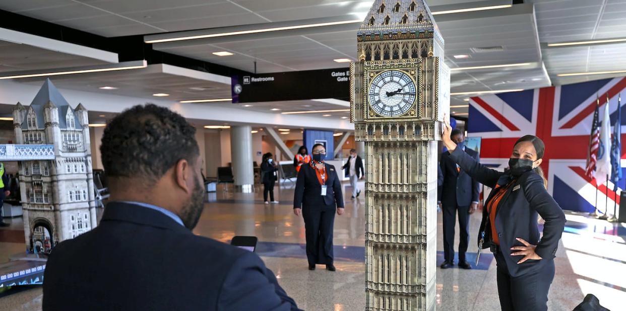 A JetBlue employee poses next to a Boston replica of London's Big Ben before the launch of nonstop flights between Boston and London in 2022. <a href="https://www.gettyimages.com/detail/news-photo/jet-blue-employee-gets-her-photograph-taken-standing-next-news-photo/1239787161?adppopup=true" rel="nofollow noopener" target="_blank" data-ylk="slk:David L. Ryan/The Boston Globe via Getty Images;elm:context_link;itc:0;sec:content-canvas" class="link ">David L. Ryan/The Boston Globe via Getty Images</a>