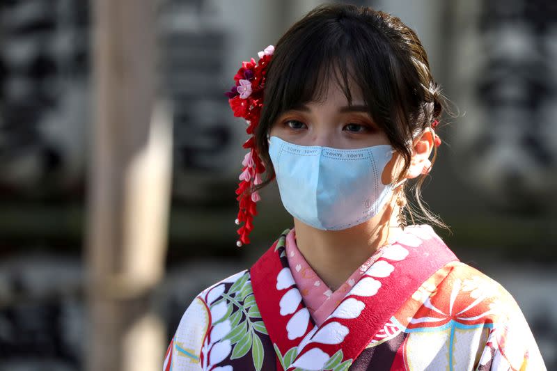 Una mujer con un kimono y una máscara facial protectora visita el Templo Sensoji en el distrito de Asakusa en Tokio, Japón