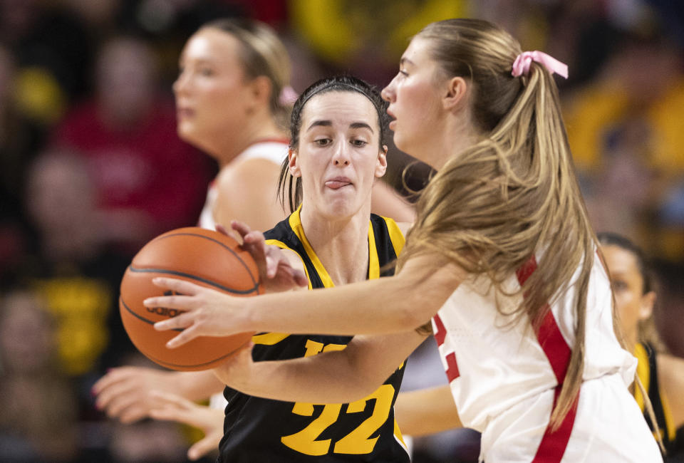 Iowa's Caitlin Clark, left, reaches for the ball as Nebraska's Logan Nissley, right, looks to pass during the second half of an NCAA college basketball game Sunday, Feb. 11, 2024, in Lincoln, Neb. (AP Photo/Rebecca S. Gratz)