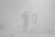 A man walks through a cloud of volcanic ash as he evacuates to safer grounds as Taal volcano in Tagaytay, Cavite province, southern Philippines on Monday, Jan. 13, 2020. Red-hot lava is gushing from the volcano after a sudden eruption of ash and steam that forced residents to flee and shut down Manila’s airport, offices and schools. (AP Photo/Aaron Favila)