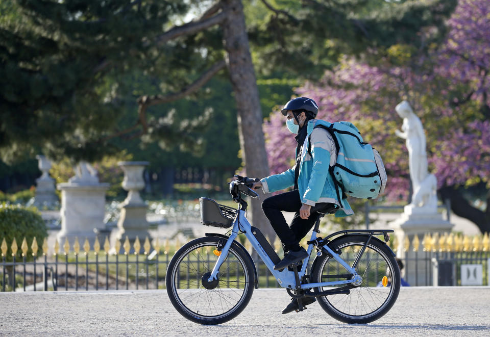 A deliveryman for Deliveroo wearing a protective mask rides his bike. Photo: Chesnot/Getty Images