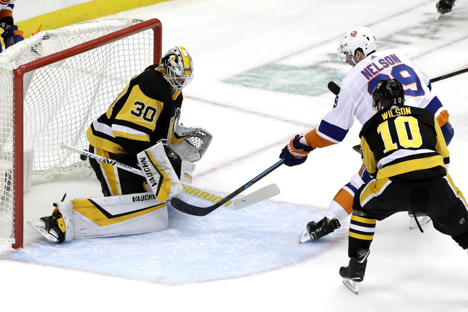 New York Islanders' Brock Nelson (29) puts a shot behind Pittsburgh Penguins goaltender Matt Murray (30) with Garrett Wilson (10) defending during the first period in Game 4 of an NHL first-round hockey playoff series in Pittsburgh, Tuesday, April 16, 2019. (AP Photo/Gene J. Puskar)