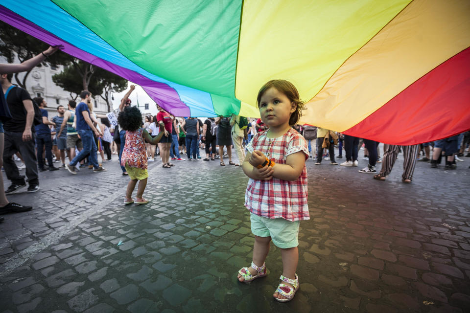 A child plays under a giant rainbow flag, a symbol of the gay rights movement, as she takes part in the 22nd annual Gay Pride parade in Rome, Italy, on June 11, 2016. (Photo by Giuseppe Ciccia/NurPhoto via Getty Images)