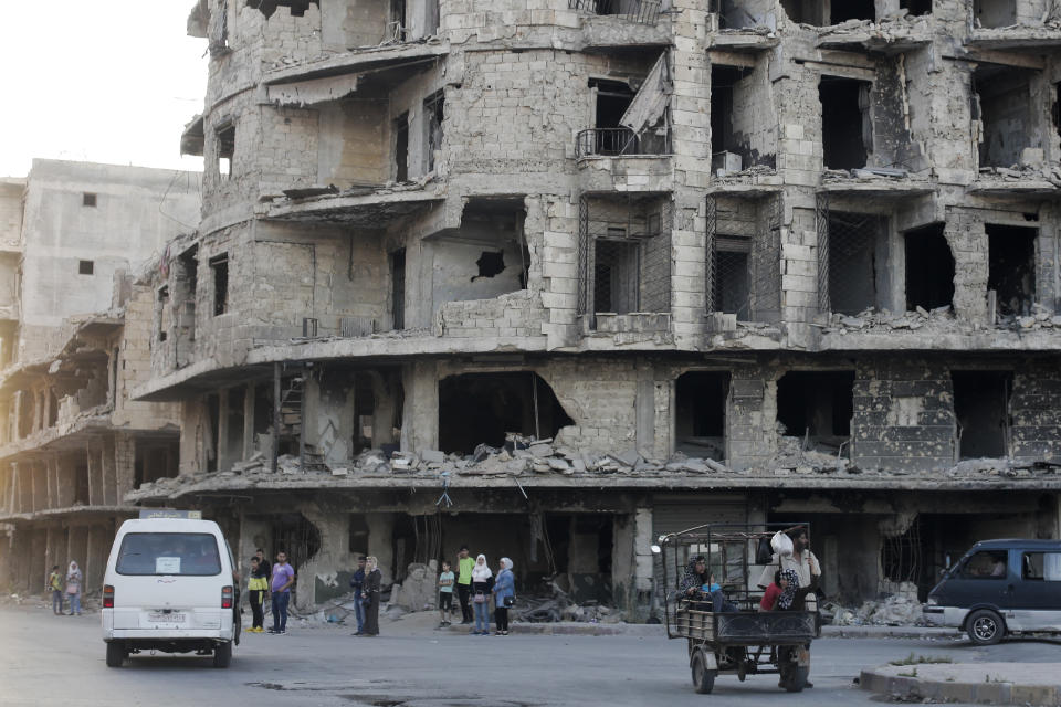 In this Friday, July 26, 2019 photo, Syrians wait for a public transportation in Aleppo, Syria. Rebels still frequently strike with shelling and mortars into Aleppo, killing civilians nearly three years after the government recaptured the city. Aleppo is a symbol of how President Bashar Assad succeeded in turning the tide in Syria’s long civil war with a series of wins, but it’s equally a symbol of how he’s been unable to secure a final victory. Half of Aleppo remains in ruins, and rebels remain on the doorstep. (AP Photo/Hassan Ammar)