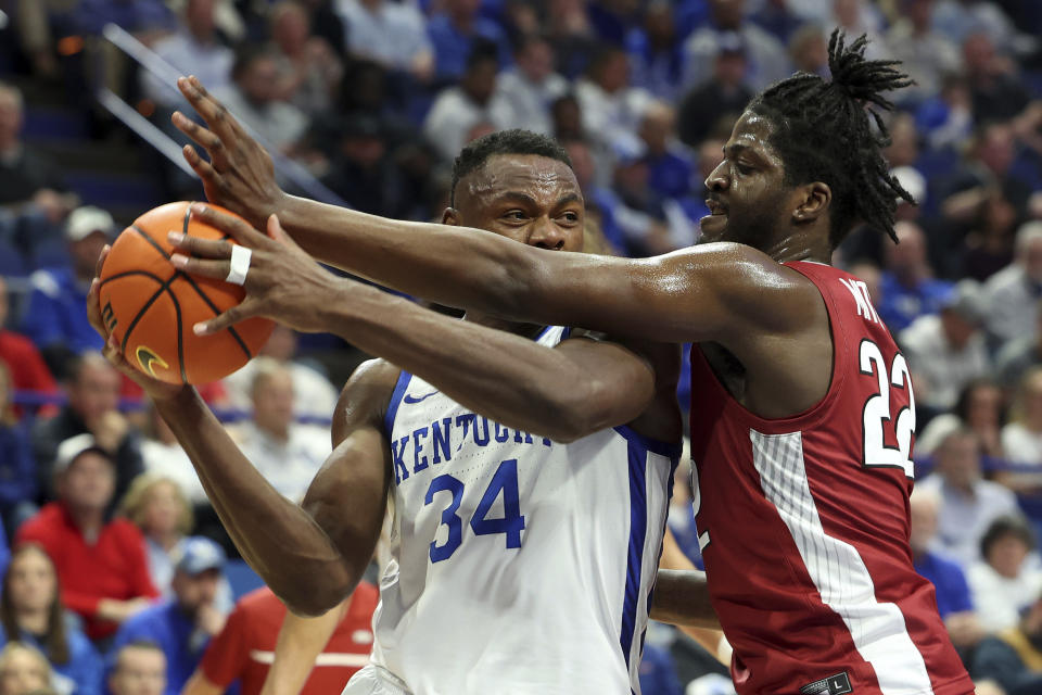 Kentucky's Oscar Tshiebwe (34) is pressured by Arkansas' Makhel Mitchell (22) during the first half of an NCAA college basketball game in Lexington, Ky., Tuesday, Feb. 7, 2023. (AP Photo/James Crisp)