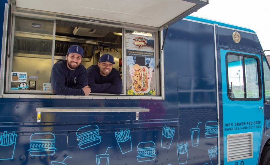 Swizzler co-founders Jesse Konig (left) and Ben Johnson (right) pose in their food truck. (Image courtesy of Jesse Konig/Swizzler)