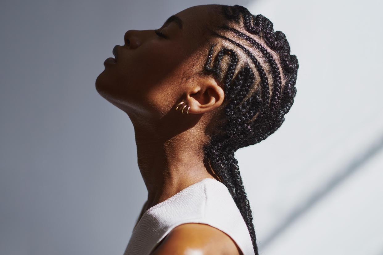 A young woman is seen in profile, her face in shadow and the back of her head in sunlight.