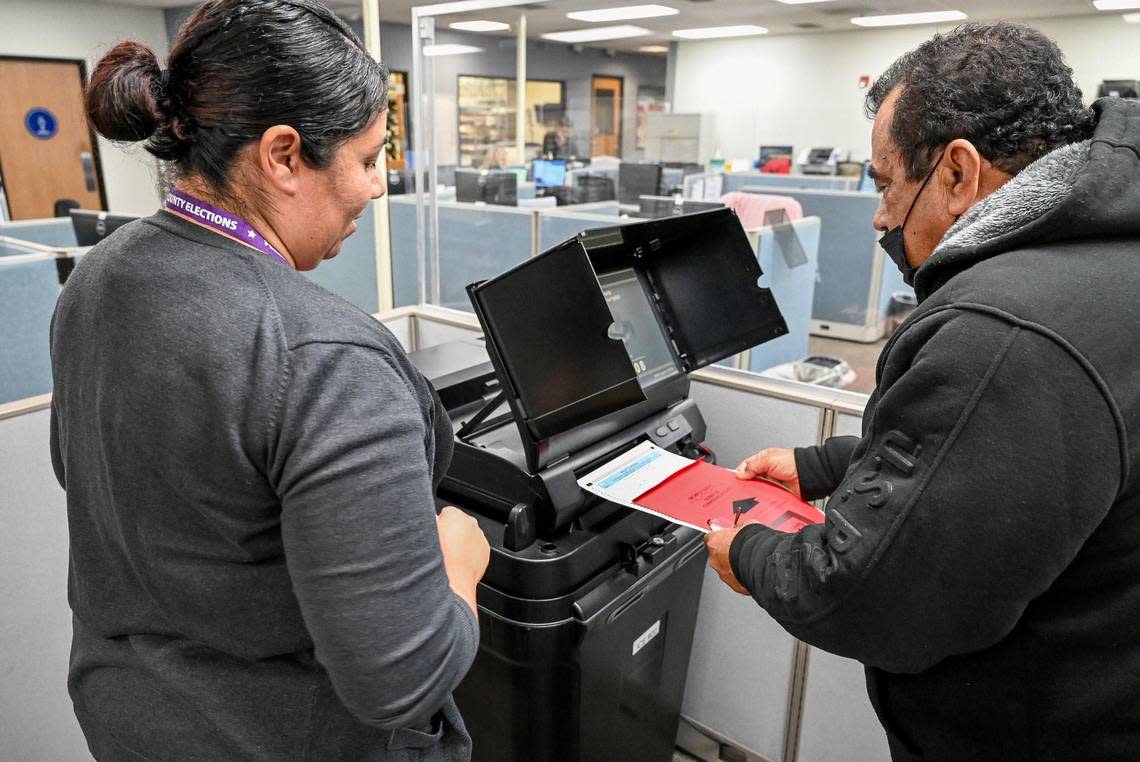 Election worker Lori Loera, left, helps voter Luis Antonio Jimenez of Fresno record his election ballot after voting in-person at the Fresno County elections office in downtown Fresno prior to Tuesday’s general election, on Monday, Nov. 7, 2022.