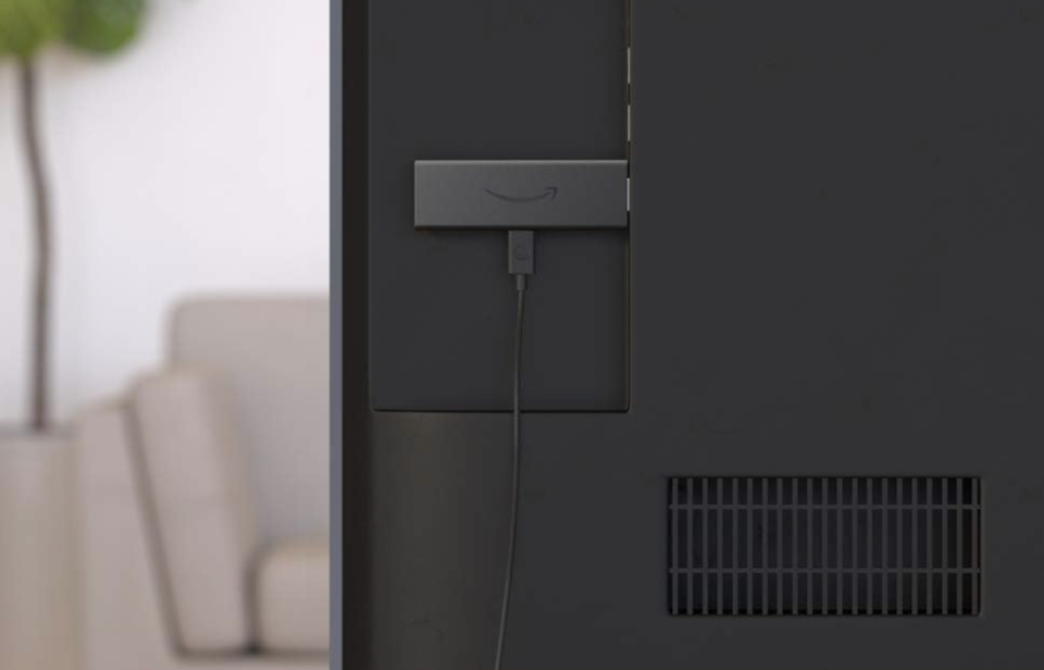 The Amazon Fire TV Stick is attached to the back of the TV