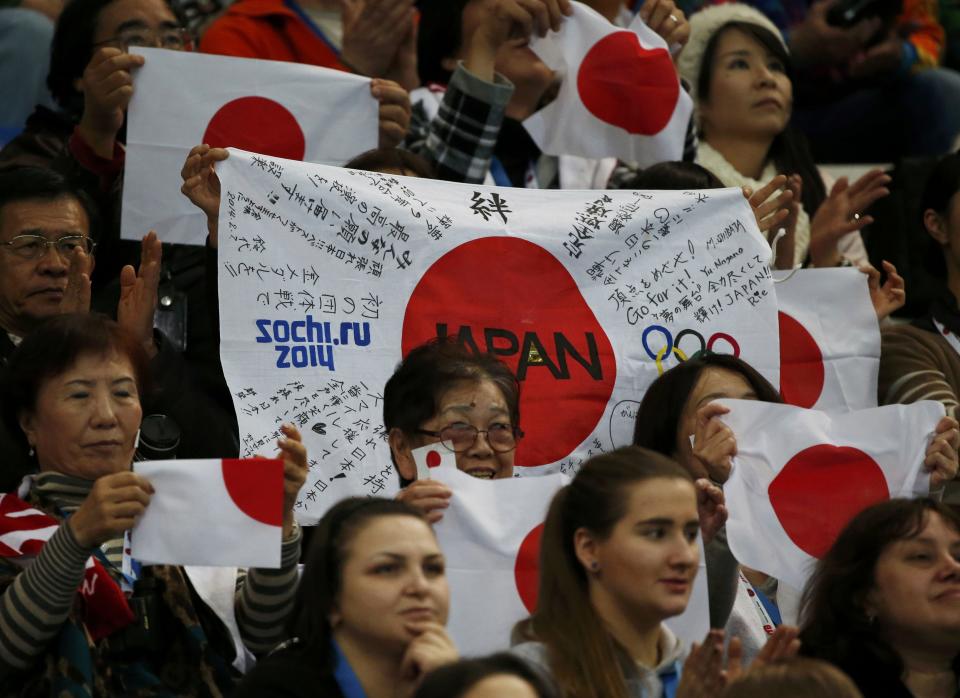 Japanese fans cheer as Cathy Reed and Chris Reed of Japan compete during the Team Ice Dance Short Dance at the Sochi 2014 Winter Olympics