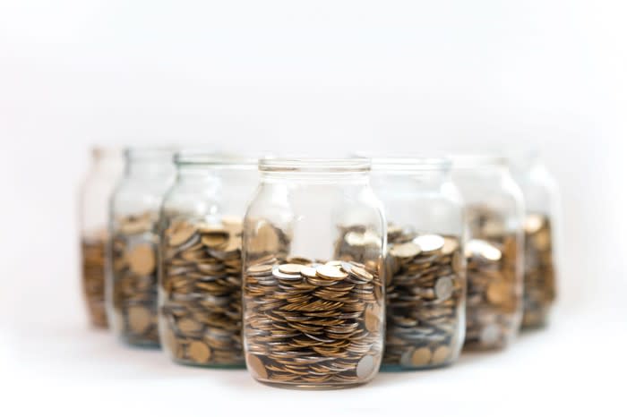 Seven glass jars filled with coins