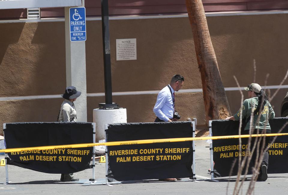 Investigators document the scene in front of the SpringHill Suites by Marriott where two people were killed in the parking lot of the building in Palm Desert, Calif., July 15, 2022.