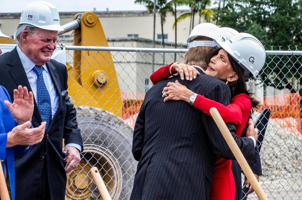 FIU Board of Trustees Chair Dean C. Colson (far left), looks on as philanthropists Trish and Dan Bell embrace each other during the groundbreaking ceremony for the Trish and Dan Bell Chapel at Florida International University on Wednesday, April 19, 2023.