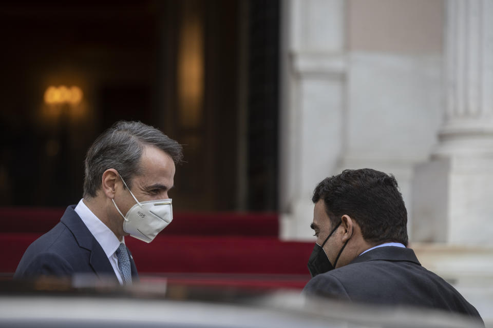 Greek Prime Minister Kyriakos Mitsotakis, left, welcomes the head of the Presidential Council of Libya Mohamed al-Menfi before their meeting, in Athens, on Wednesday, April 14, 2021. (AP Photo/Petros Giannakouris)