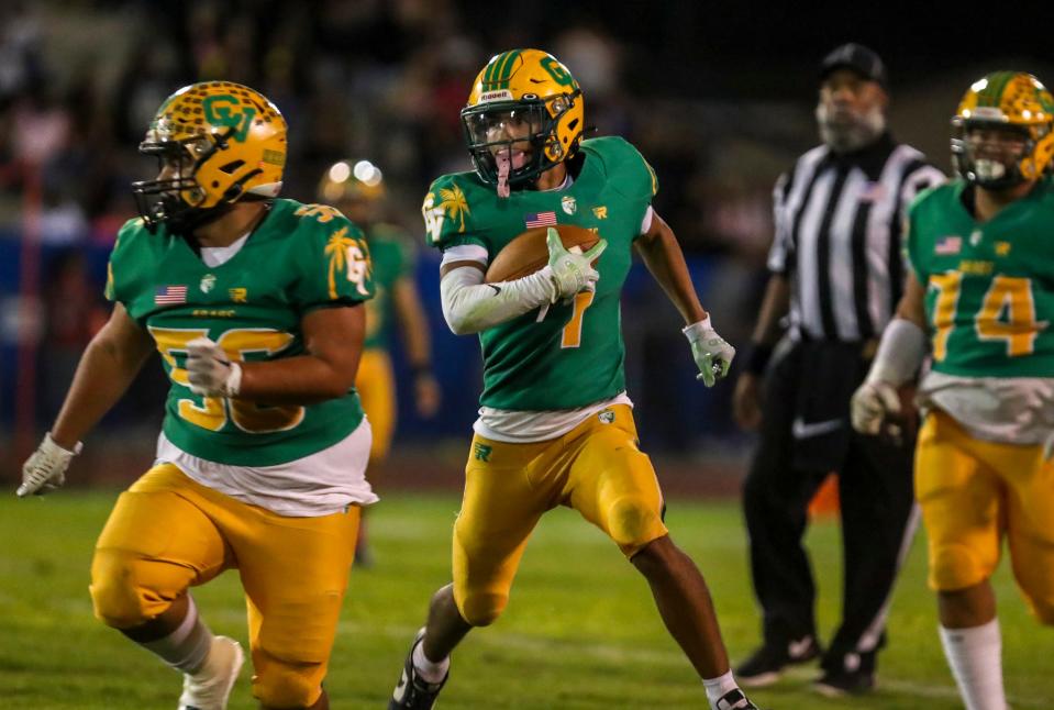 Coachella Valley's Mikey Rodriguez (1) runs the ball as teammate Reymundo Pena (56) looks to make a block during the second quarter of their game in Indio, Calif., Friday, Oct. 27, 2023.