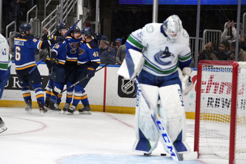 St. Louis Blues' Pavel Buchnevich (89) is congratulated by teammates after scoring past Vancouver Canucks goaltender Thatcher Demko, right, during the second period of an NHL hockey game Tuesday, March 28, 2023, in St. Louis. (AP Photo/Jeff Roberson)