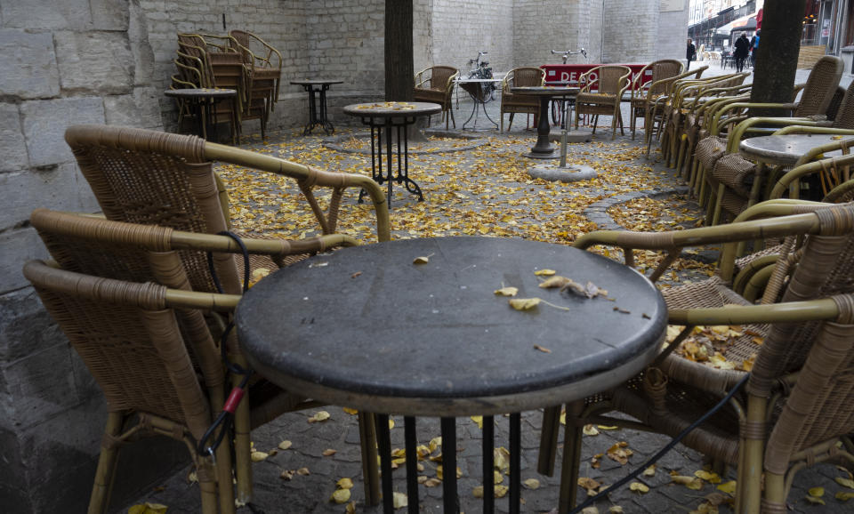 Terrace chairs and tables are chained together in the historic center of Antwerp, Belgium, Sunday, Oct. 18, 2020. Faced with a resurgence of coronavirus cases, the Belgian government on Friday announced new restrictions to try to hold the disease in check, including a night-time curfew and the closure of cafes, bars and restaurants for a month. The measures will take effect on Monday, Oct. 19, 2020. (AP Photo/Virginia Mayo)