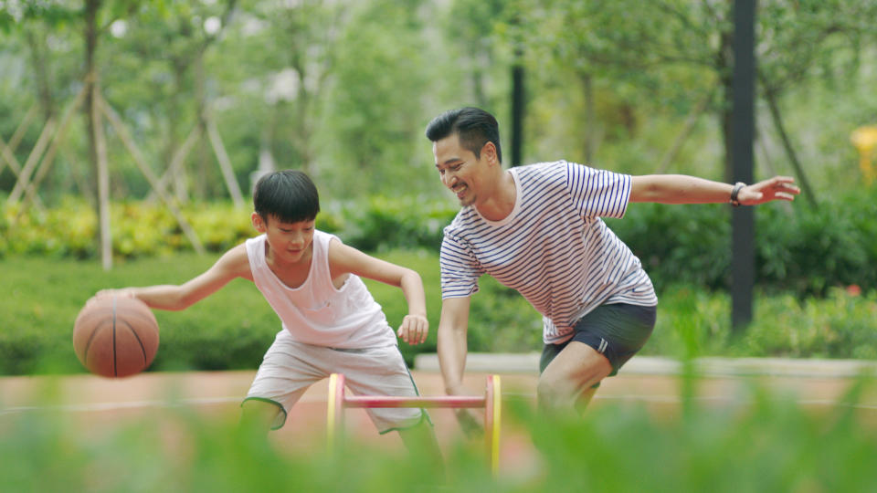 Father and son playing basketball together.