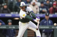 Colorado Rockies' Alan Trejo breaks his bat while grounding into a force play against Seattle Mariners starting pitcher Luis Castillo in the third inning of a baseball game Saturday, April 20, 2024, in Denver. (AP Photo/David Zalubowski)