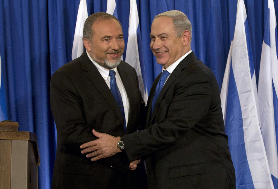 FILE - In this Oct. 25, 2012, file photo, Israeli Prime Minister Benjamin Netanyahu, right, and former Israeli Defense Minister Avigdor Lieberman shake hands in front of the media after giving a statement in Jerusalem. Israel's parliament voted to dissolve itself early Thursday, May 30, 2019, sending the country to an unprecedented second snap election this year as Netanyahu failed to form a governing coalition before a midnight deadline. (AP Photo/Bernat Armangue, File)