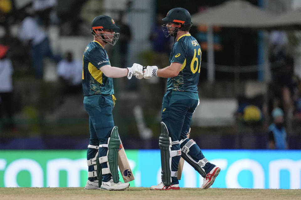 Australia's David Warner, left, and teammate Travis Head gesture to each other during the ICC Men's T20 World Cup cricket match between Australia and Bangladesh in North Sound, Antigua and Barbuda, Thursday, June 20, 2024. (AP Photo/Lynne Sladky)
