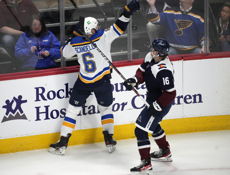 St. Louis Blues defenseman Marco Scandella, left, pursues the puck with Colorado Avalanche right wing Nicolas Aube-Kubel in the first period of an NHL hockey game Tuesday, April 26, 2022, in Denver. (AP Photo/David Zalubowski)