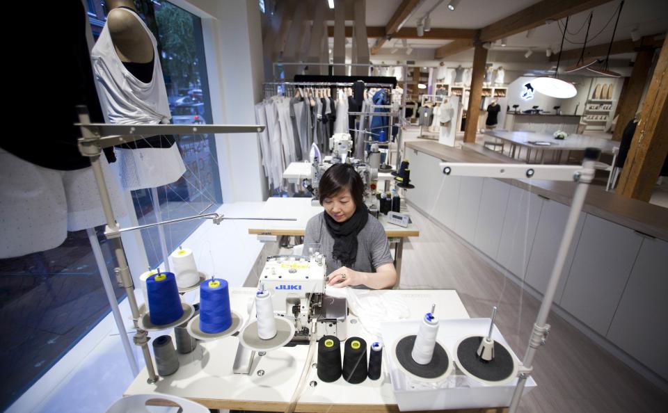 A designer works at the Kit and Ace flagship store in Vancouver, British Columbia October 17, 2014. Kit and Ace is the brainchild of billionaire Chip Wilson's wife, former Lululemon lead designer Shannon Wilson, who started the new streetwear venture with his son J.J. Backed entirely by Wilson family money, Kit and Ace has started with one store in the heart of Vancouver's artsy Gastown neighborhood. The shop specializes in "technical" luxury: cashmere-blend casual wear that is pre-shrunk, washable and durable. Picture taken October 17, 2014. REUTERS/Ben Nelms (CANADA - Tags: BUSINESS FASHION)