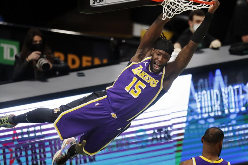 Los Angeles Lakers' Montrezl Harrell hangs from the rim after a dunk during the second half.